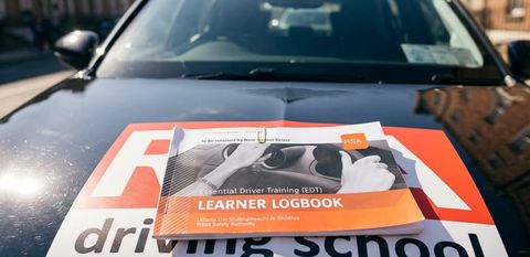 EDT learner logbook on the bonnet of an RSA School of Motoring car